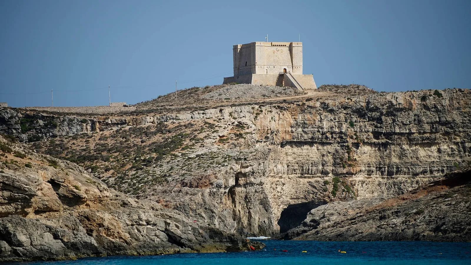 La Torre de Santa María en lo alto del acantilado de Comino, sobre una cueva y el agua azul de la laguna