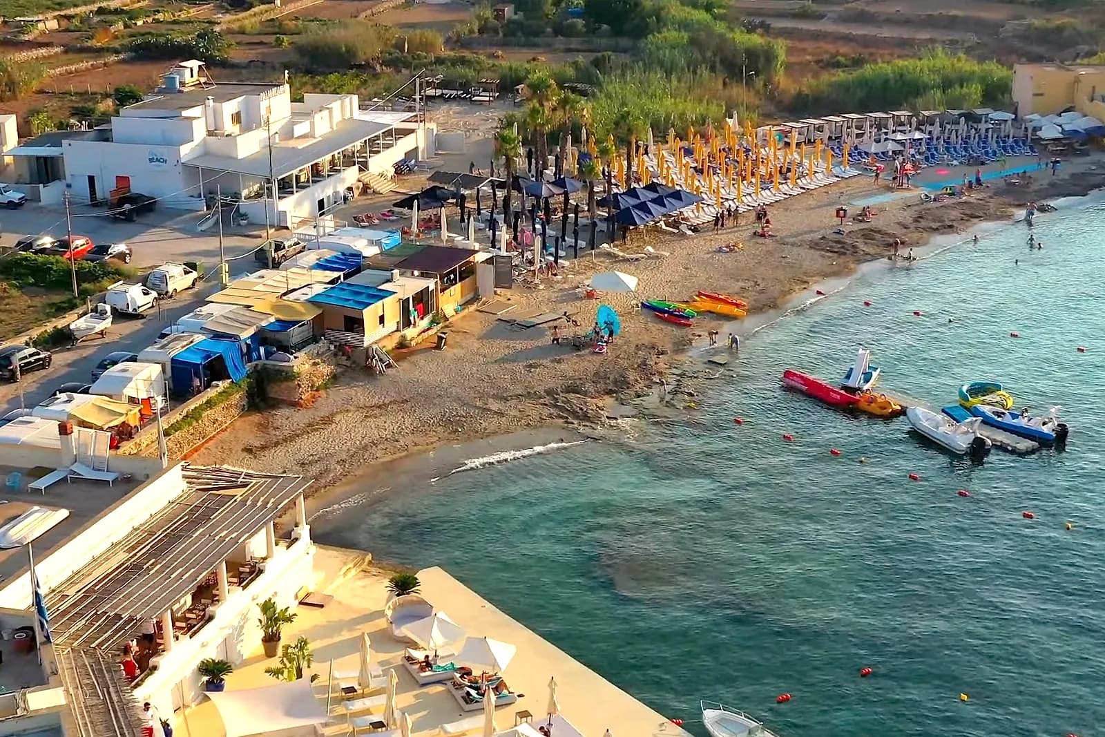 Armier Bay con los lidos, las hamacas y las barcas en el agua clara