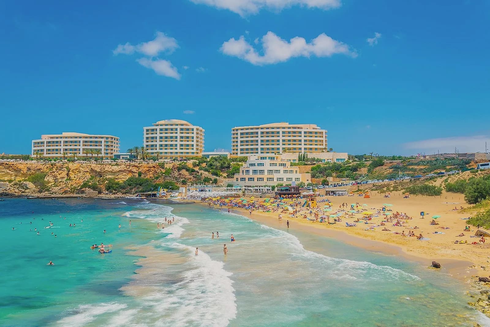 Golden Bay desde el acantilado, con la arena dorada, el agua turquesa y el hotel al fondo