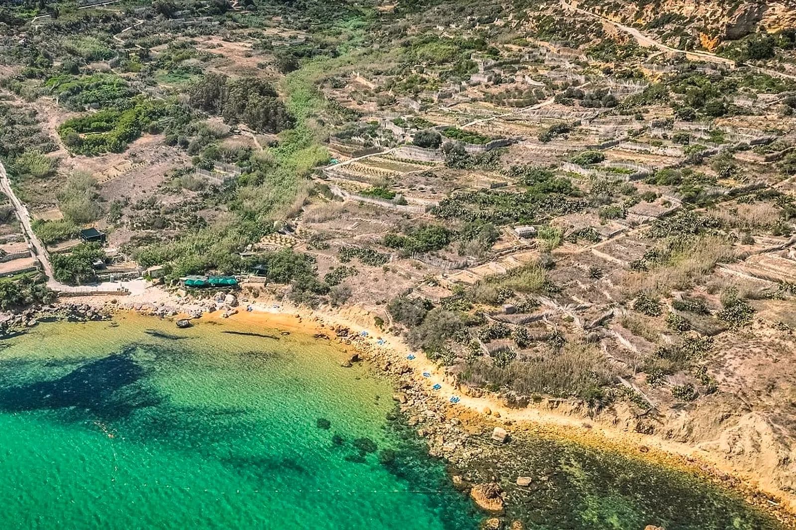 San Blas desde lo alto, con la cala de arena, el agua verde turquesa y el valle de terrazas de cultivo