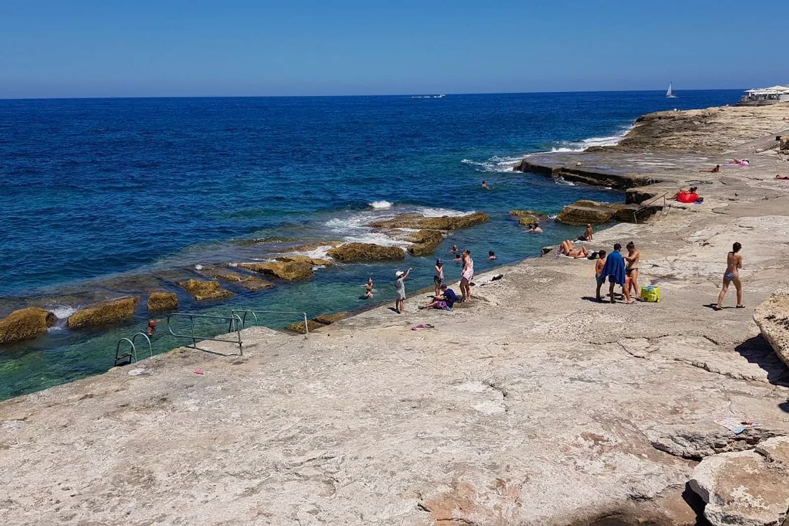 La plataforma de roca de Qui-Si-Sana, en Sliema, con gente tomando el sol junto al mar
